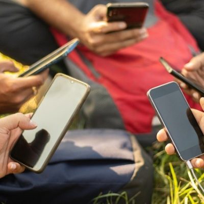 Close up of young people hands holding mobile - College Students addicted to smartphone - young millennials busy on cell phone - Group of friends sharing content on social media